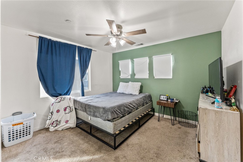 507 Villa Way Colton, CA 92324 - Photo 23 of 34 a bedroom with a bed a chandelier and a dresser