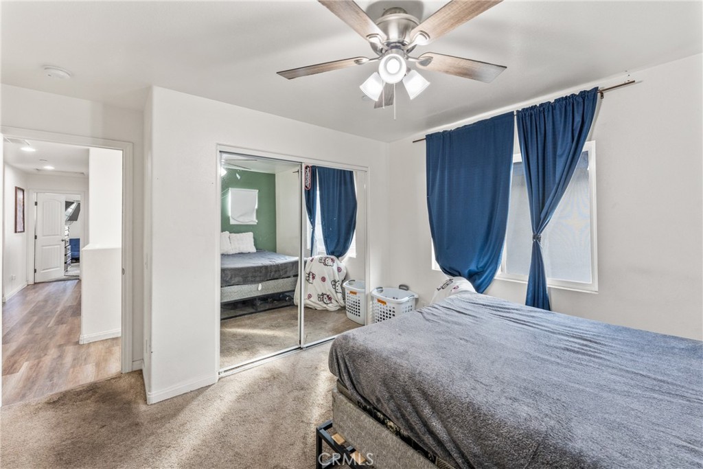 507 Villa Way Colton, CA 92324 - Photo 24 of 34 a bedroom with a bed a chandelier and a dresser