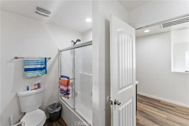 a white toilet sitting next to a bathroom sink and a shower
