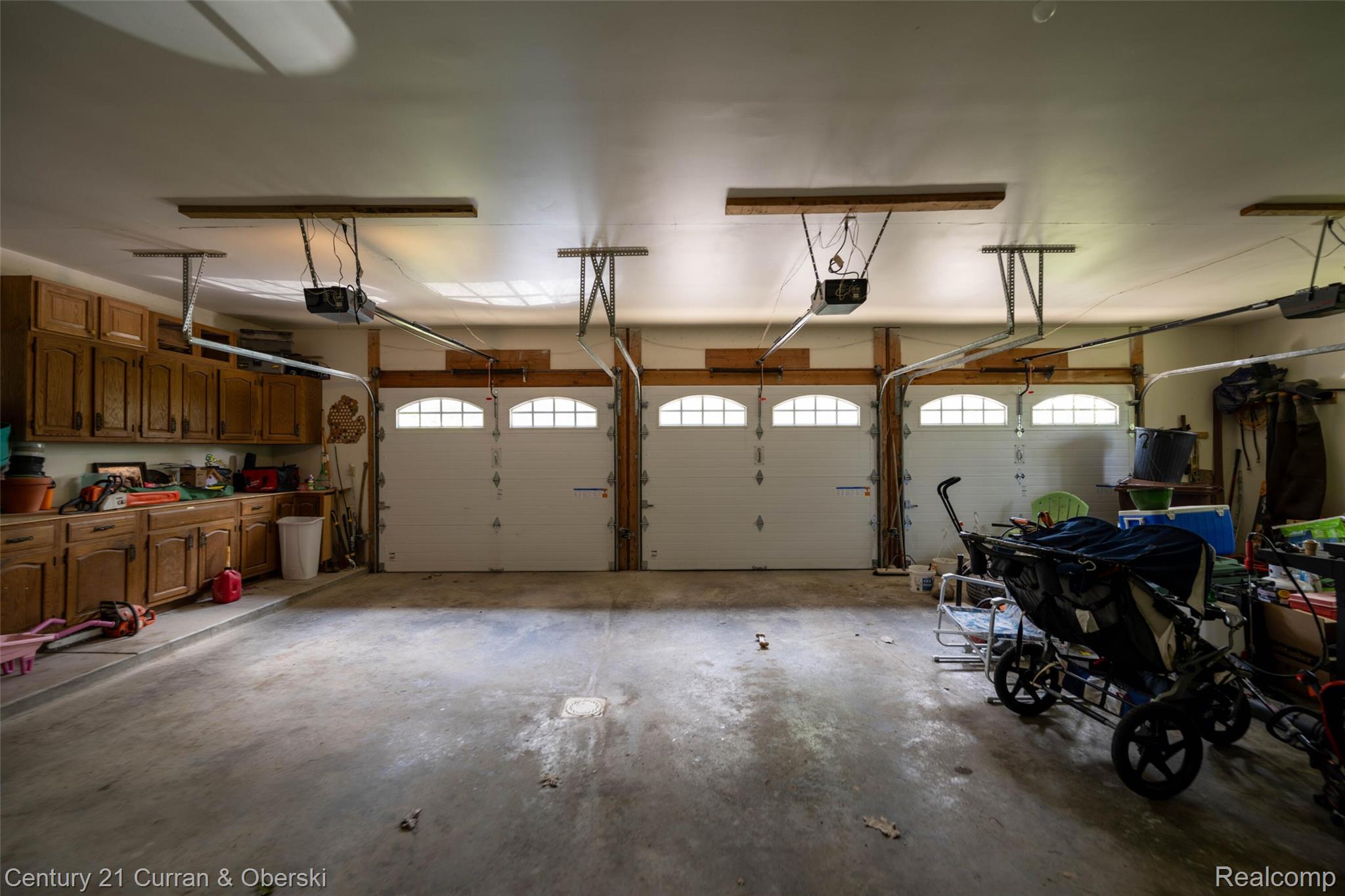 8775 Winding Rdg Drive Millersburg, MI 49759 - Photo 48 of 53 Three-car garage with white paneled doors featuring arched window inserts