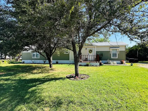 a front view of a house with yard and green space