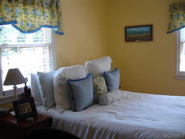 1007 Horsepen Road Richmond, VA 23229 - Photo 6 of 8 a bed sitting in a bedroom next to a window with a chair
