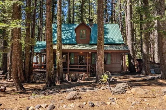 a view of a house with backyard and trees
