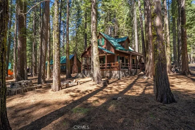 a view of swimming pool with lawn chairs and large trees