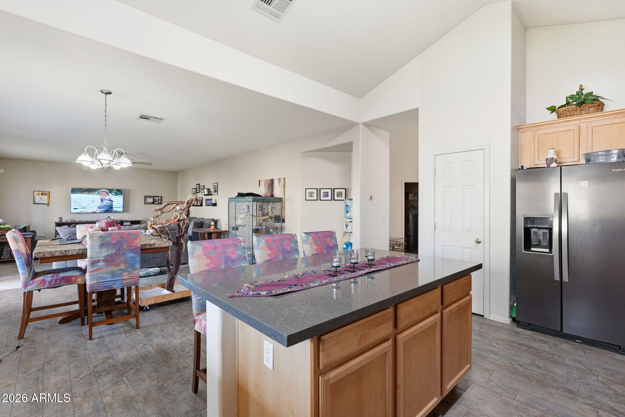 17760 West Charter Oak Road Surprise, AZ 85388 - Photo 15 of 45 a kitchen with stainless steel appliances kitchen island granite countertop a table chairs and a refrigerator