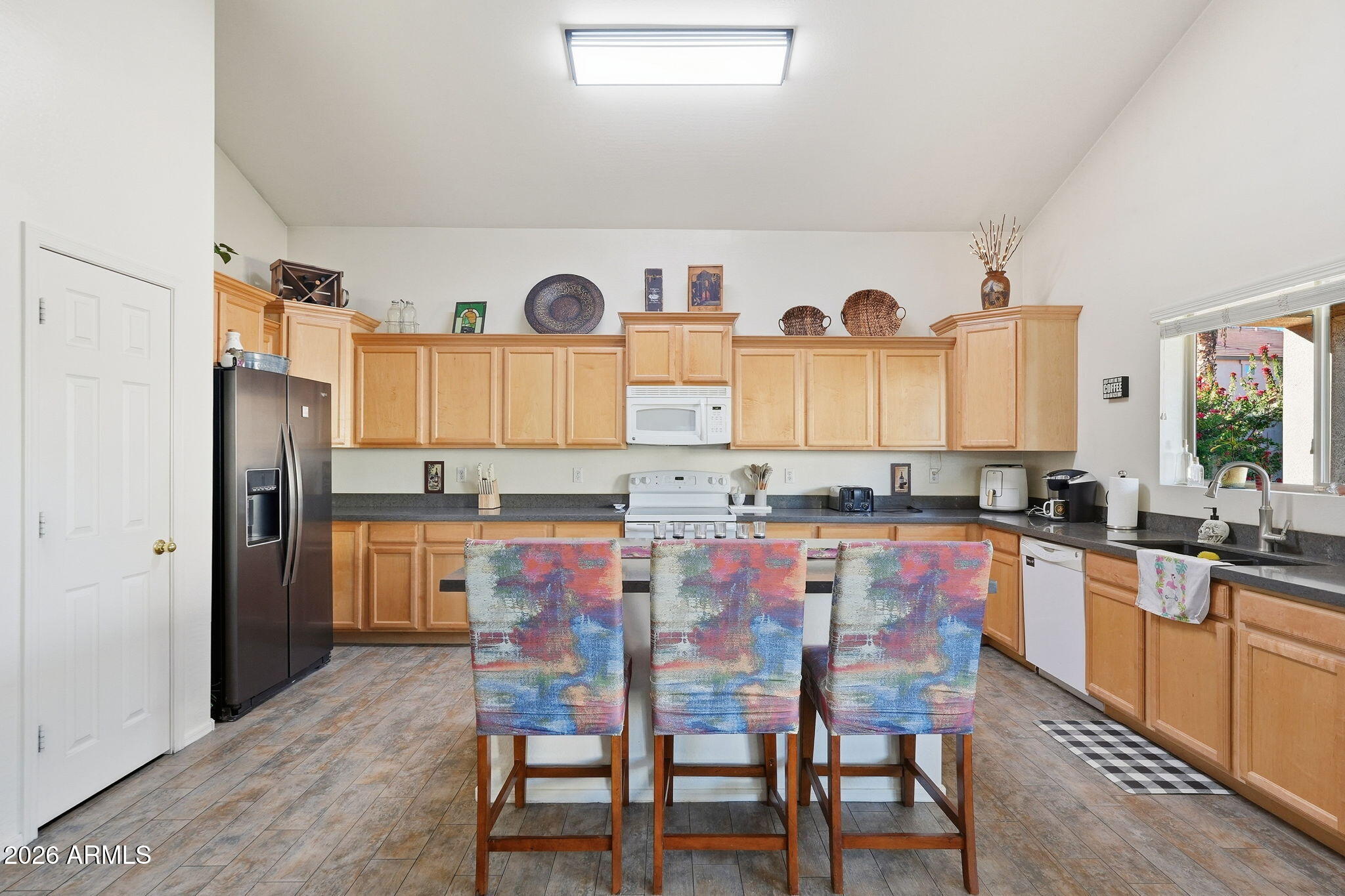17760 West Charter Oak Road Surprise, AZ 85388 - Photo 17 of 45 a large kitchen with granite countertop a refrigerator and a stove top oven