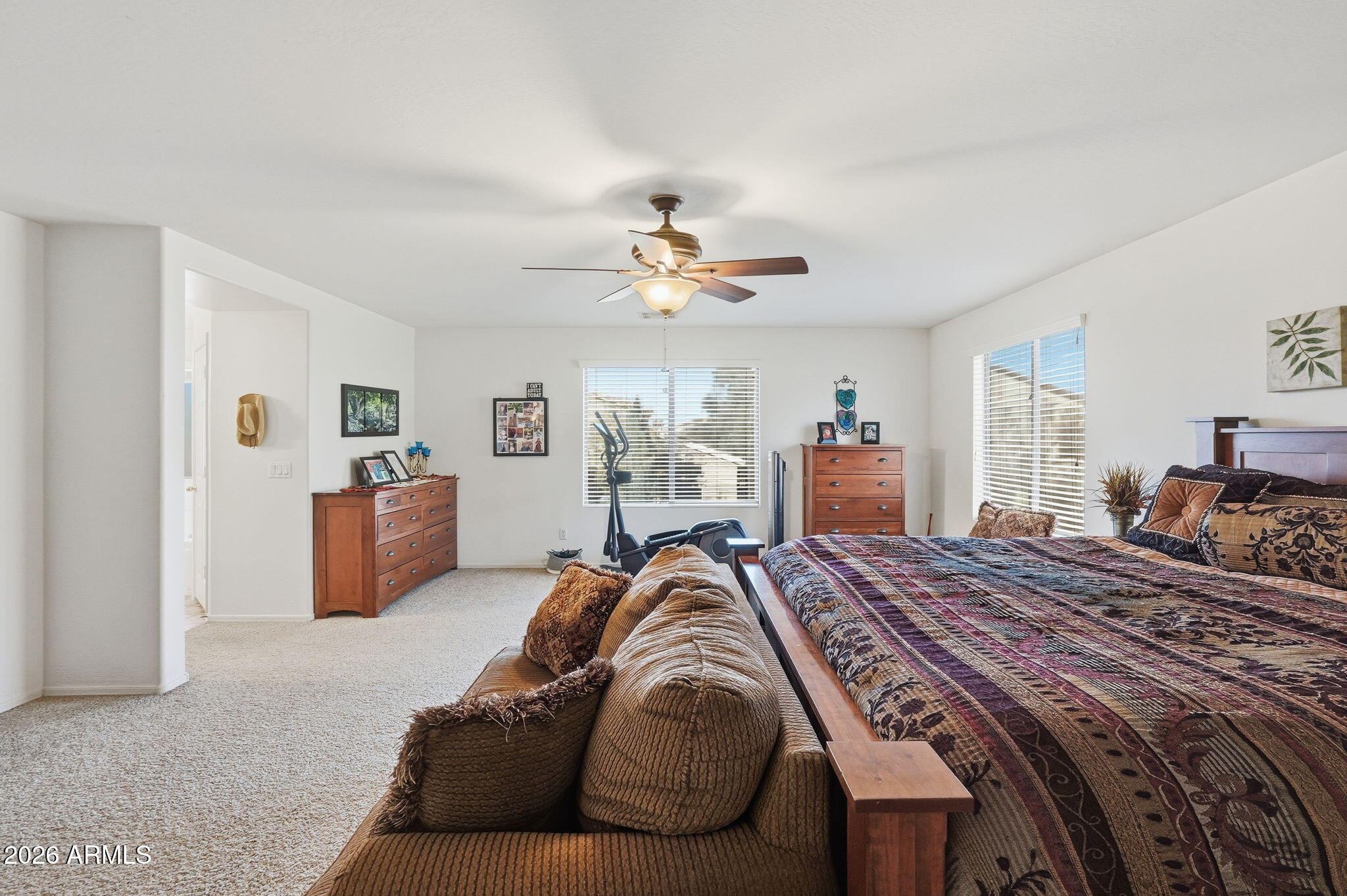 17760 West Charter Oak Road Surprise, AZ 85388 - Photo 25 of 45 a bedroom with a large bed and a chandelier