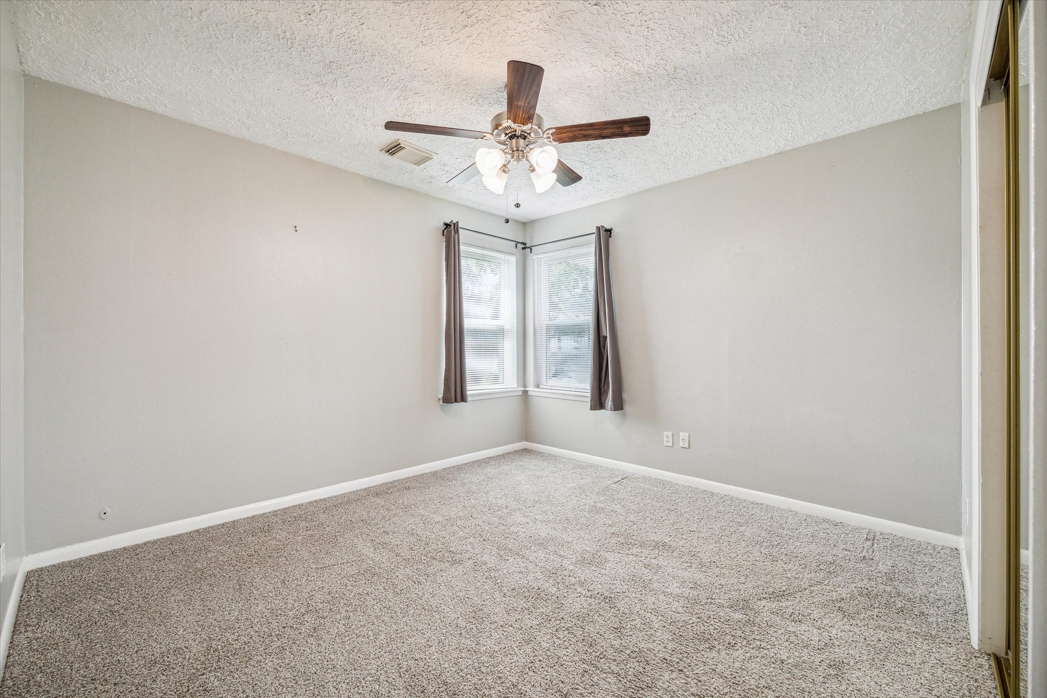 3613 Lazy Spring Drive Houston, TX 77080 - Photo 15 of 22 an empty room with windows and ceiling fan