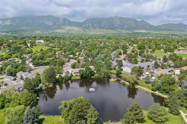an aerial view of residential houses with outdoor space and lake view