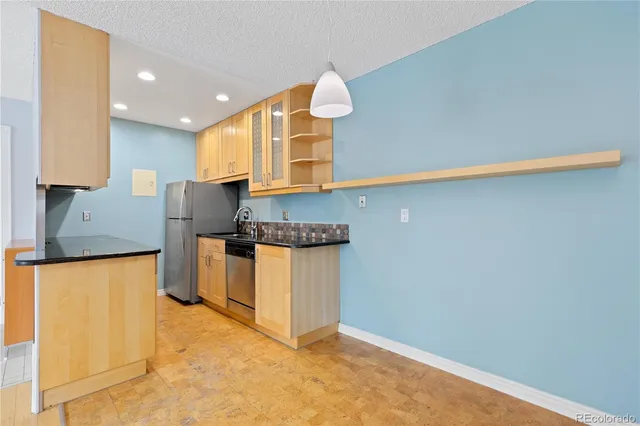 a kitchen with granite countertop sink and cabinets