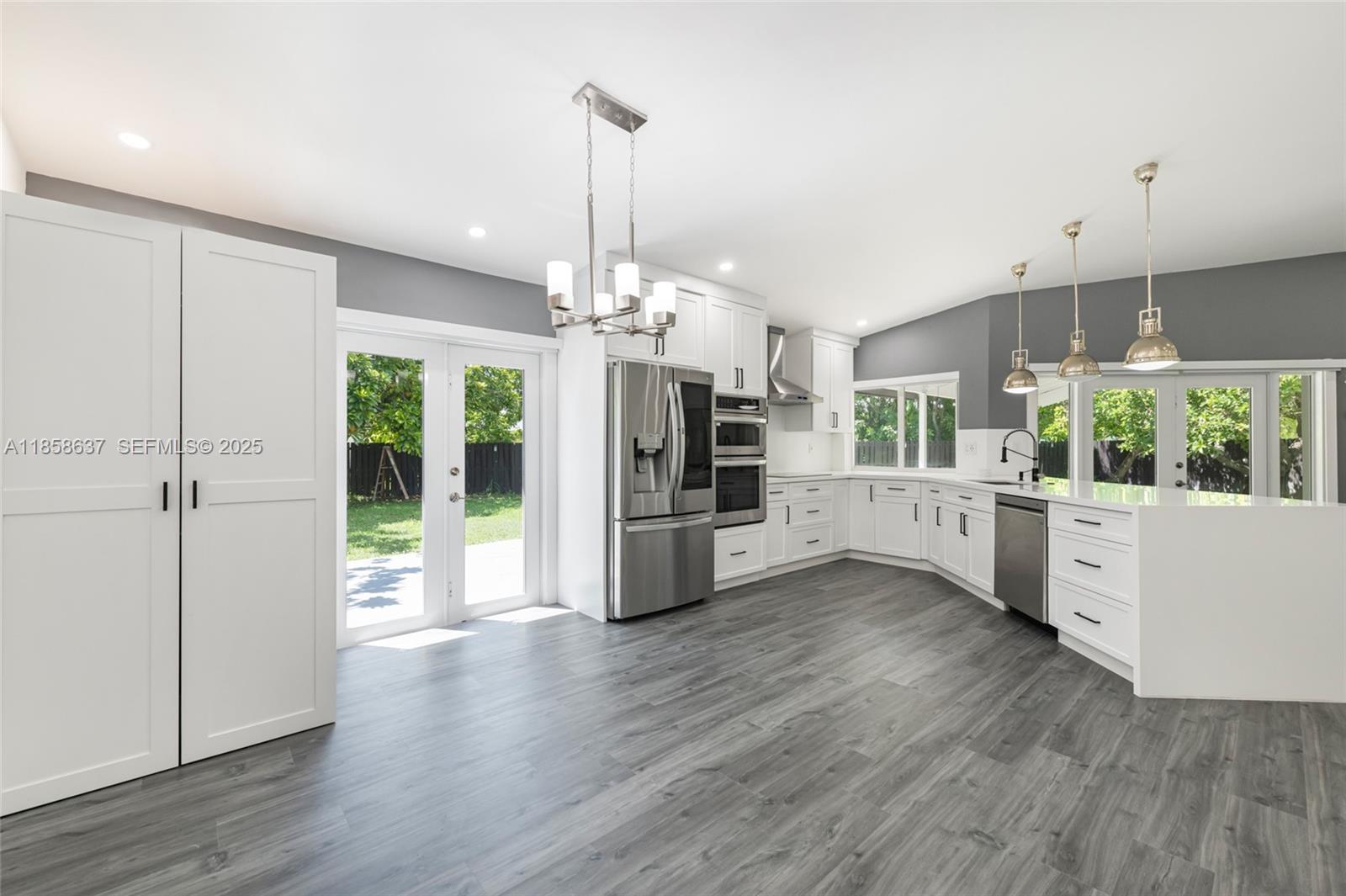 11518 Southwest 174th Street Miami, FL 33157 - Photo 11 of 27 a open kitchen with stainless steel appliances granite countertop a stove top oven a sink with wooden floor and cabinets