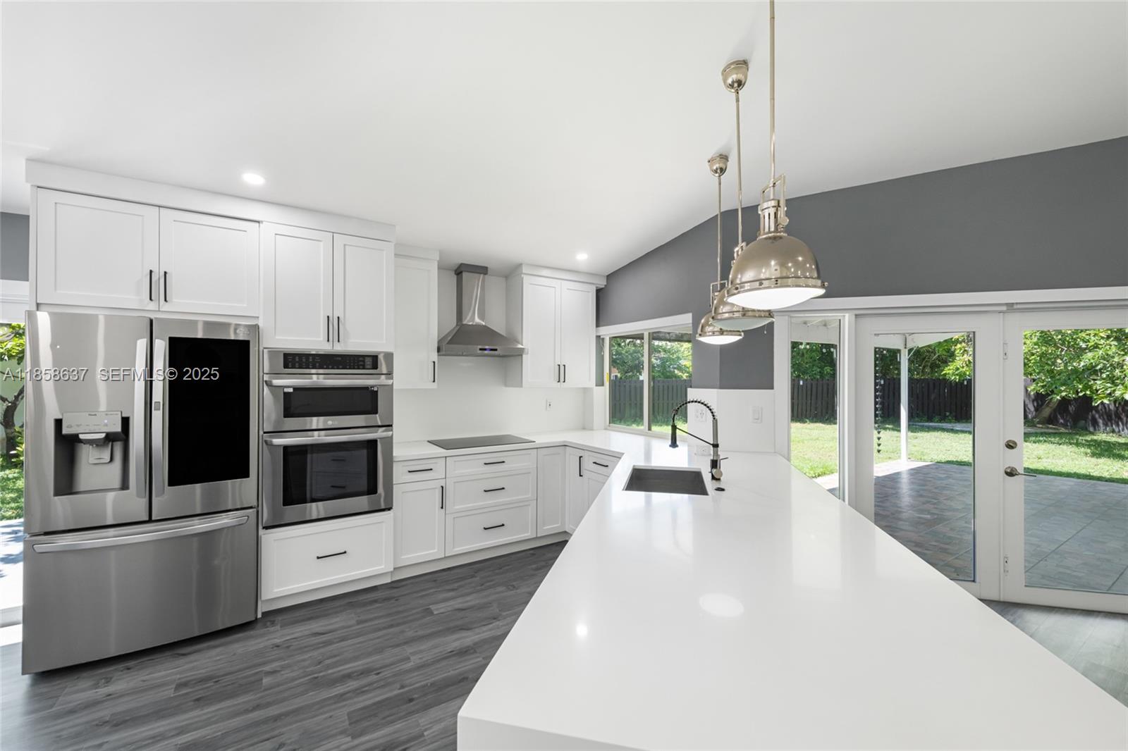 11518 Southwest 174th Street Miami, FL 33157 - Photo 13 of 27 a kitchen with stainless steel appliances a stove a sink dishwasher a refrigerator white cabinets and wooden floor next to a window