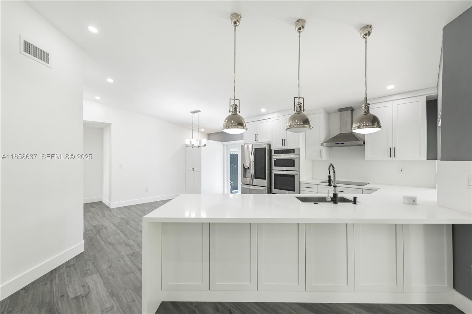 11518 Southwest 174th Street Miami, FL 33157 - Photo 14 of 27 a view of a kitchen with kitchen island a sink and a wooden floor