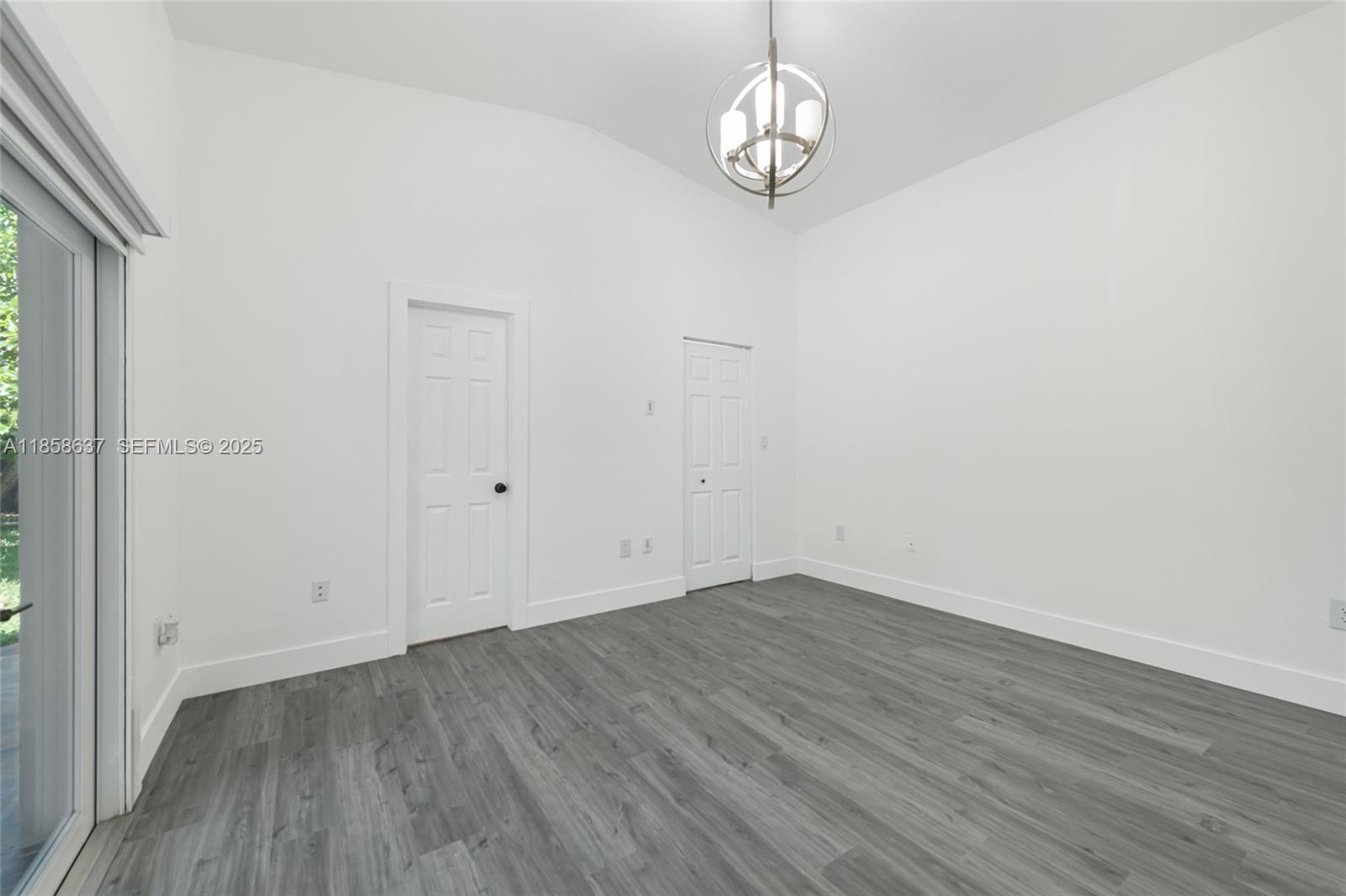 11518 Southwest 174th Street Miami, FL 33157 - Photo 16 of 27 a view of empty room with wooden floor and window