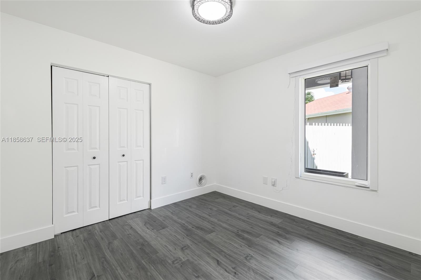 11518 Southwest 174th Street Miami, FL 33157 - Photo 20 of 27 an empty room with wooden floor and window