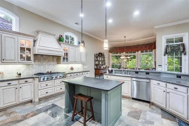 a kitchen with stainless steel appliances granite countertop a sink a stove and a wooden floors