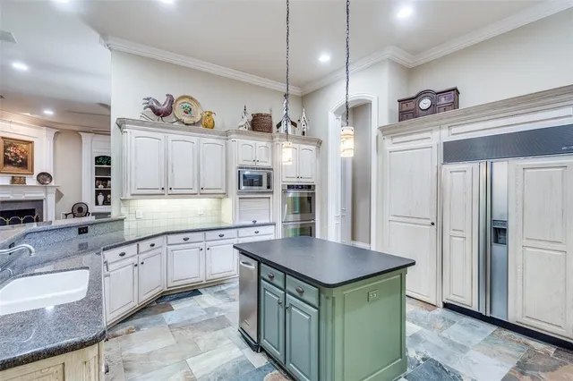 a kitchen with granite countertop a sink a counter space appliances and cabinets