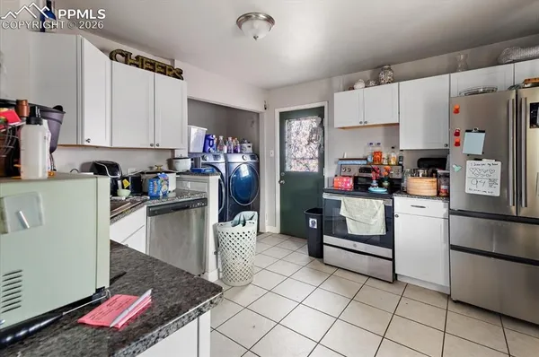 a kitchen with a refrigerator and white cabinets