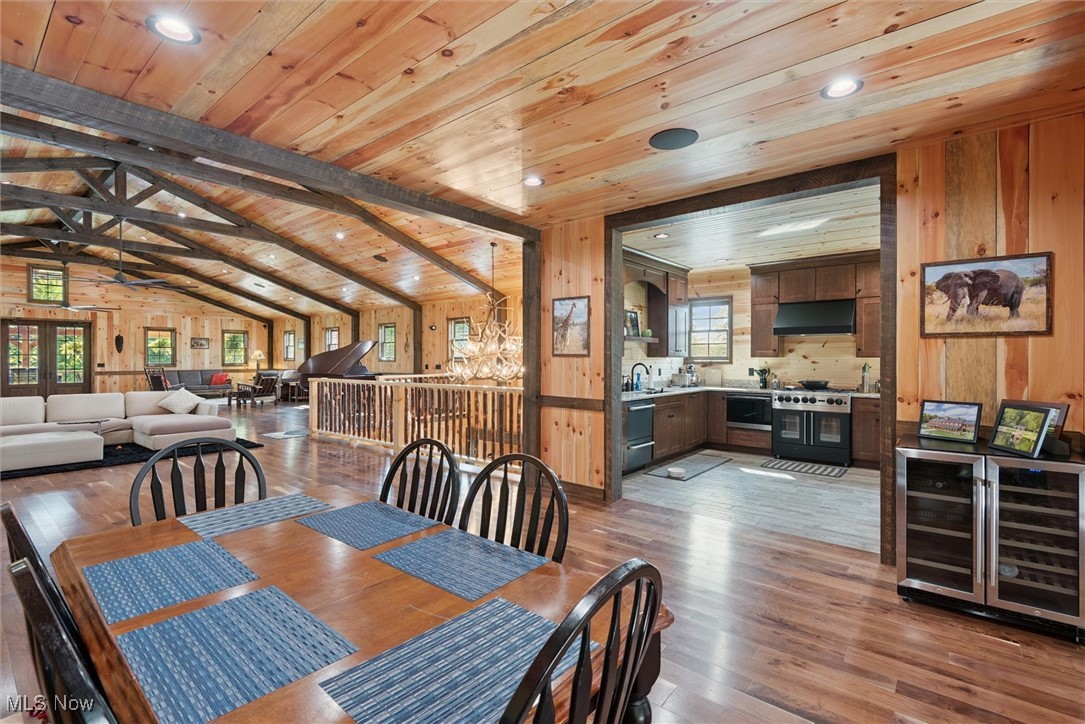 290 Townline Road Aurora, OH 44202 - Photo 14 of 50 Dining room with light wood finished floors, wine cooler, wood walls, wooden ceiling, and recessed lighting