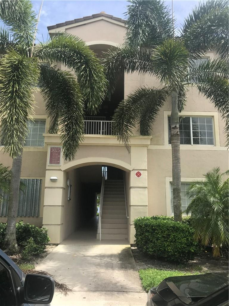 5025 Wiles Road, Unit 207 Coconut Creek, FL 33073 - Photo 2 of 6 a front view of a house with a yard