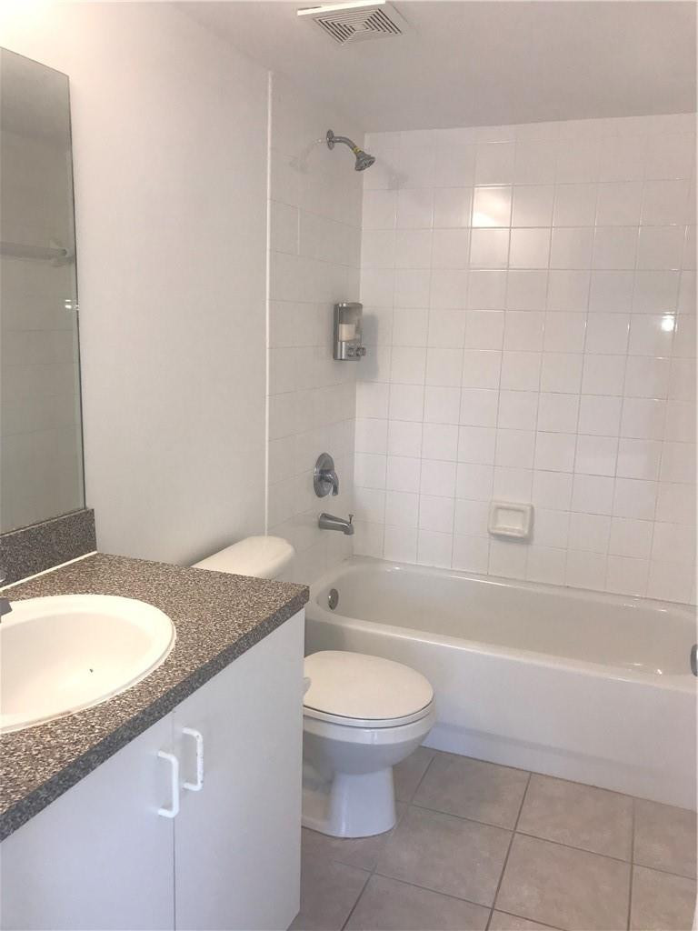 5025 Wiles Road, Unit 207 Coconut Creek, FL 33073 - Photo 3 of 6 a bathroom with a granite countertop sink a toilet and shower