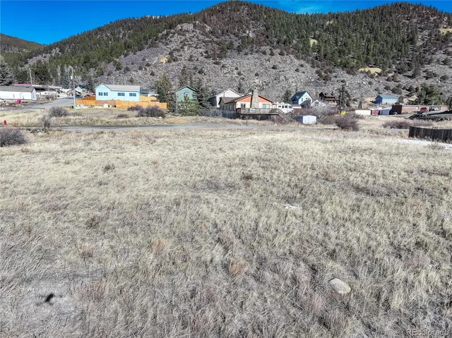 a view of a dry yard with wooden fence