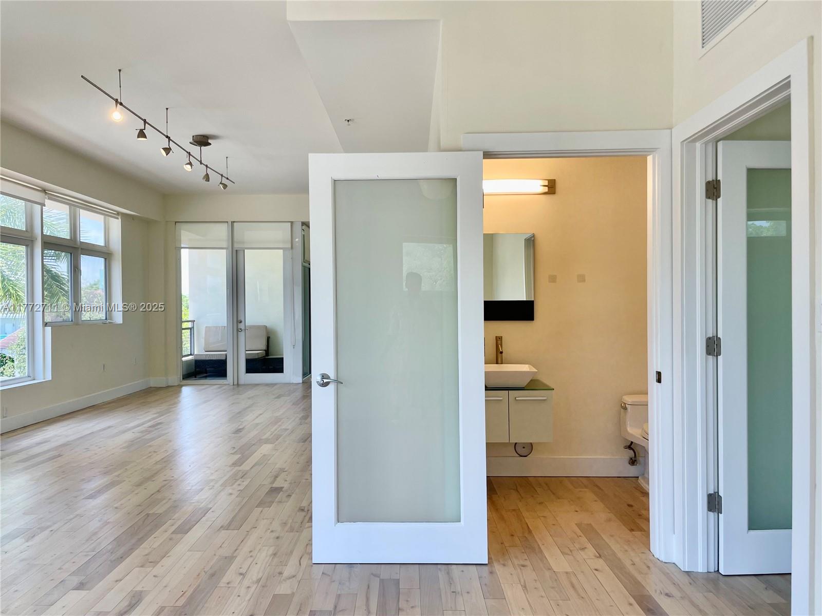 6701 Biscayne Boulevard, Unit 201 Miami, FL 33138 - Photo 14 of 22 a view of a hallway with wooden floor and a bathroom