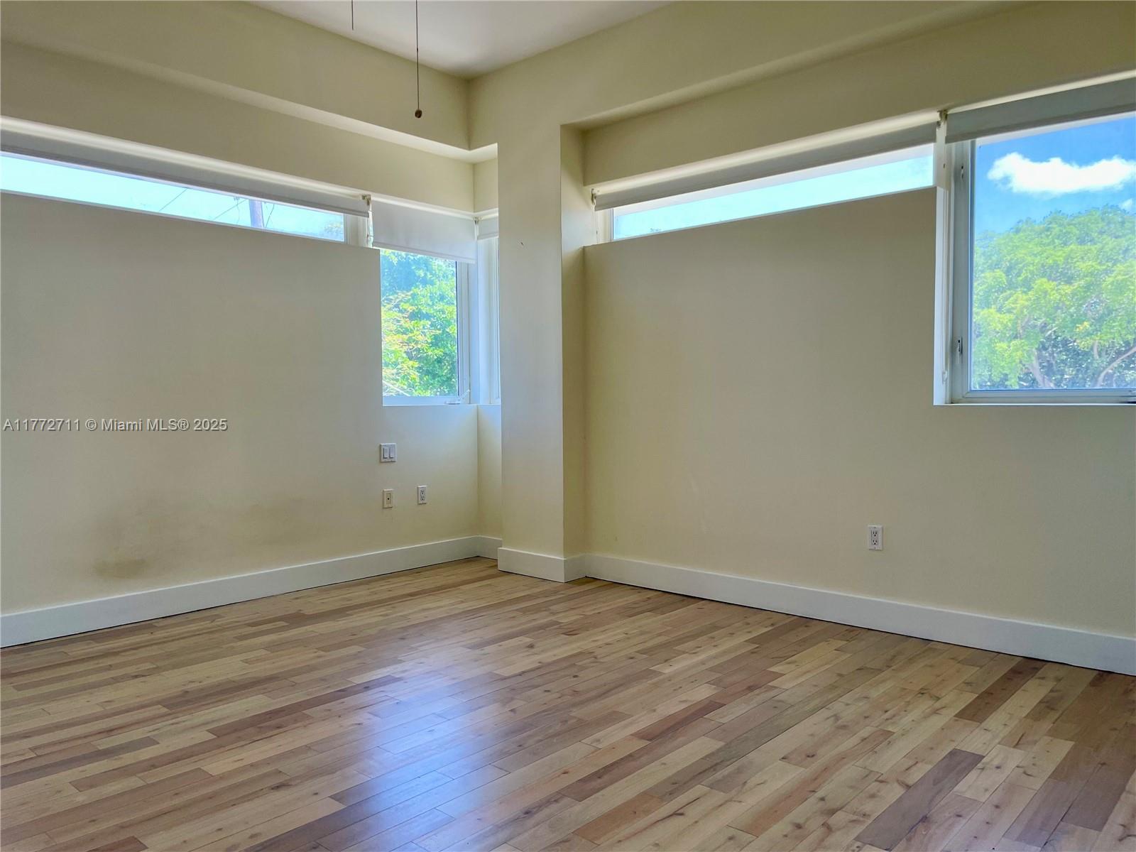 6701 Biscayne Boulevard, Unit 201 Miami, FL 33138 - Photo 16 of 22 a view of an empty room with wooden floor and a window