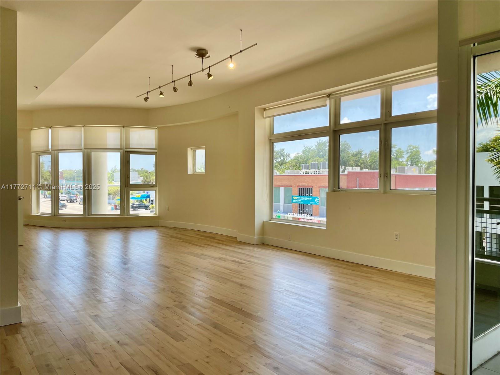 6701 Biscayne Boulevard, Unit 201 Miami, FL 33138 - Photo 10 of 22 a view of an empty room with wooden floor and a window