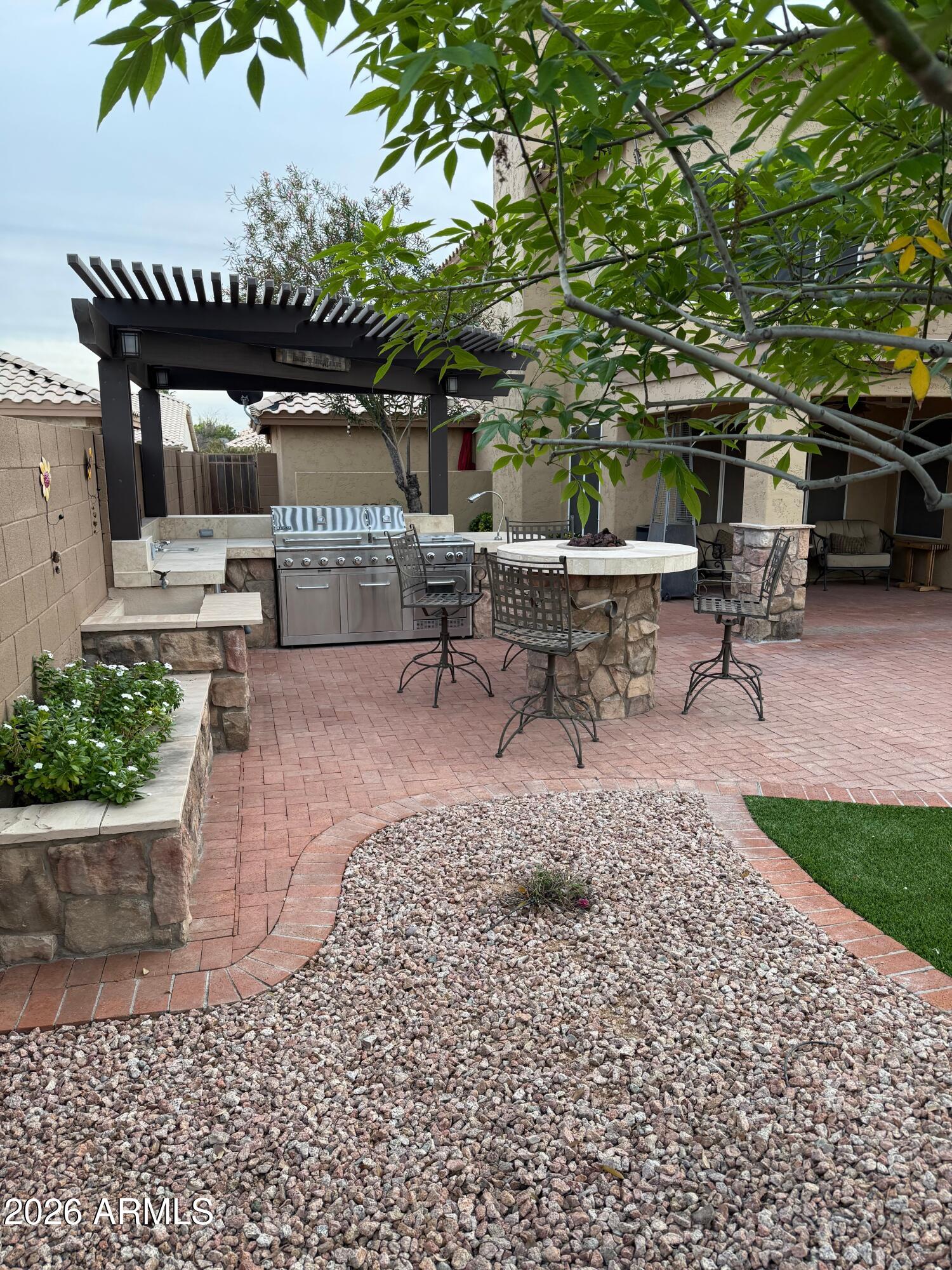 3426 East Clark Road Phoenix, AZ 85050 - Photo 39 of 48 a view of a patio with table and chairs potted plants and a large tree