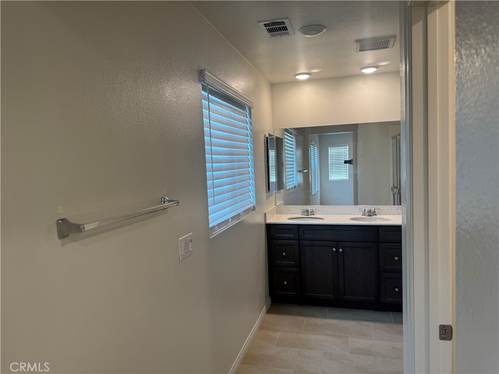 28582 Buttercup Way Moreno Valley, CA 92555 - Photo 30 of 55 a spacious bathroom with a double vanity sink and mirror