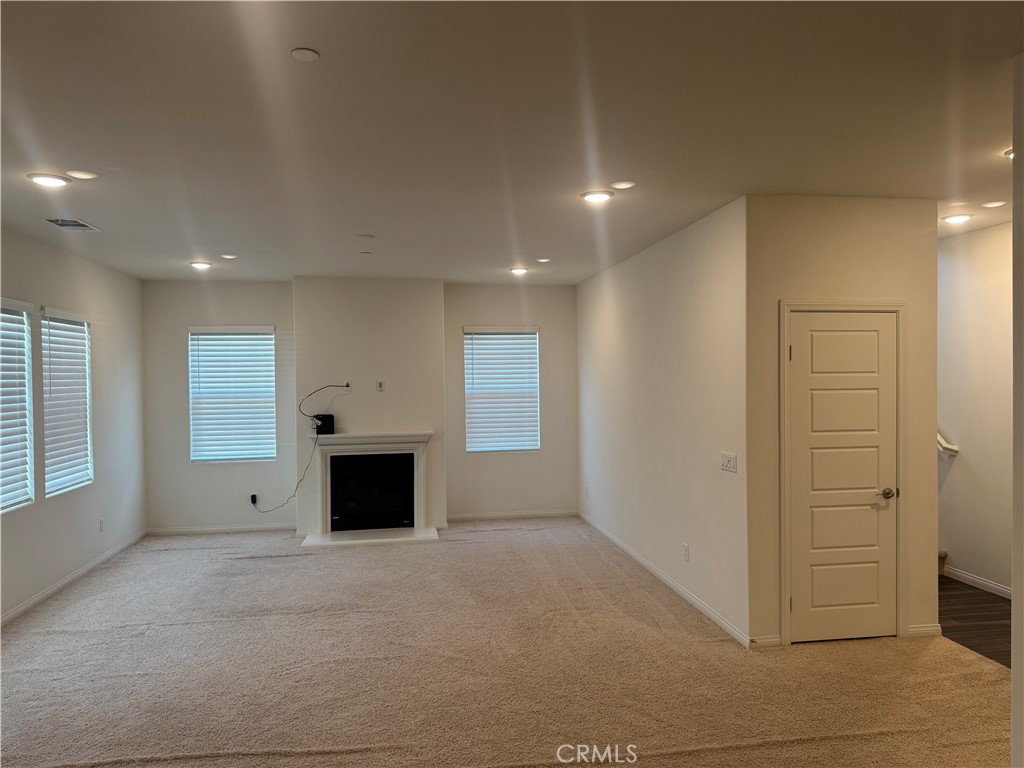 28582 Buttercup Way Moreno Valley, CA 92555 - Photo 3 of 55 an empty room with windows and fireplace