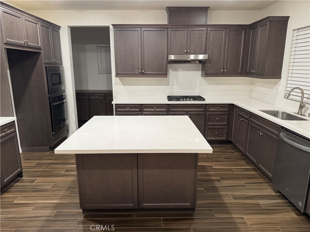 28582 Buttercup Way Moreno Valley, CA 92555 - Photo 10 of 55 a kitchen with a sink a refrigerator and wooden cabinets