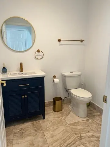 a bathroom with a toilet a sink and mirror