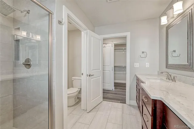 a spacious bathroom with a granite countertop sink a toilet and shower