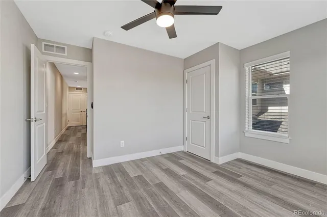 a view of a livingroom with wooden floor and a ceiling fan