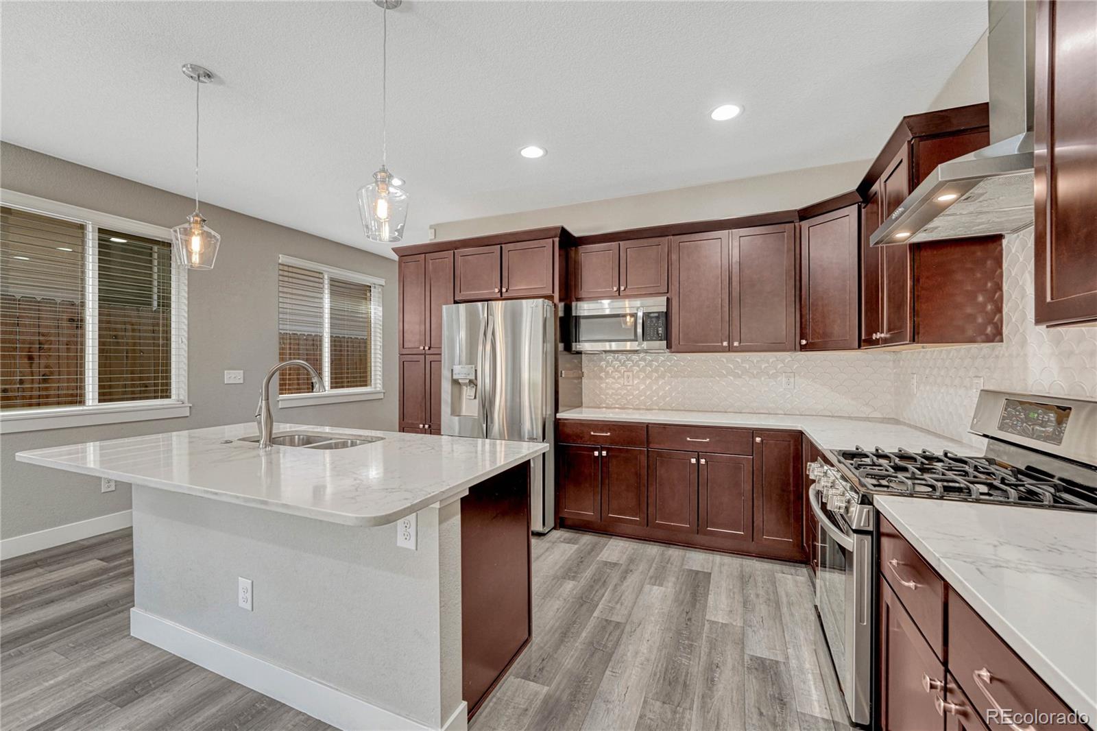 923 Raleigh Street Denver, CO 80204 - Photo 3 of 35 a kitchen with stainless steel appliances granite countertop a sink stove and refrigerator