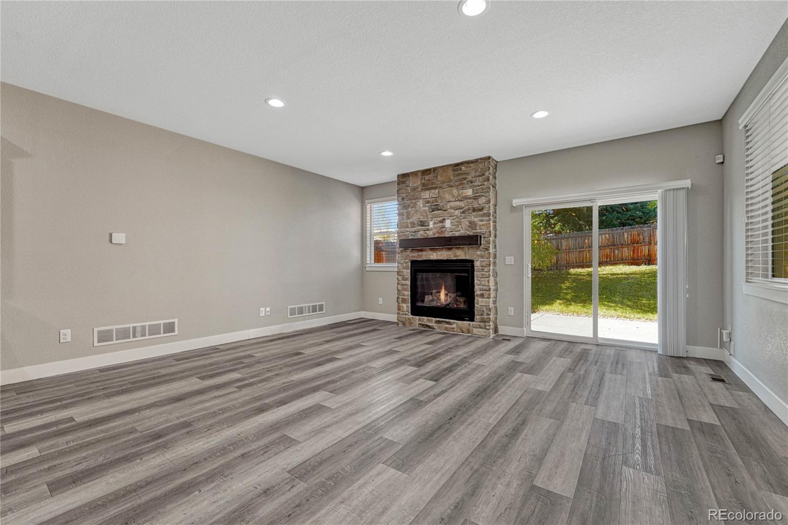 923 Raleigh Street Denver, CO 80204 - Photo 6 of 35 an empty room with wooden floor a fireplace and windows