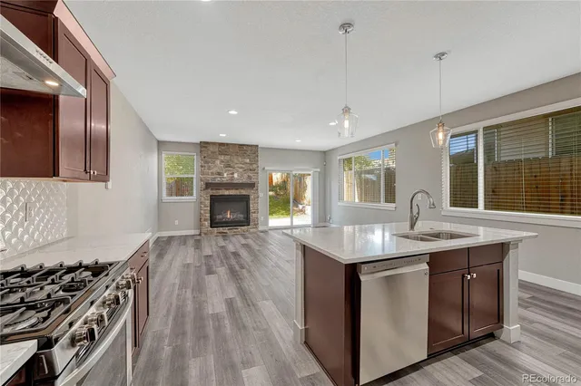 a kitchen with granite countertop a sink stove and cabinets