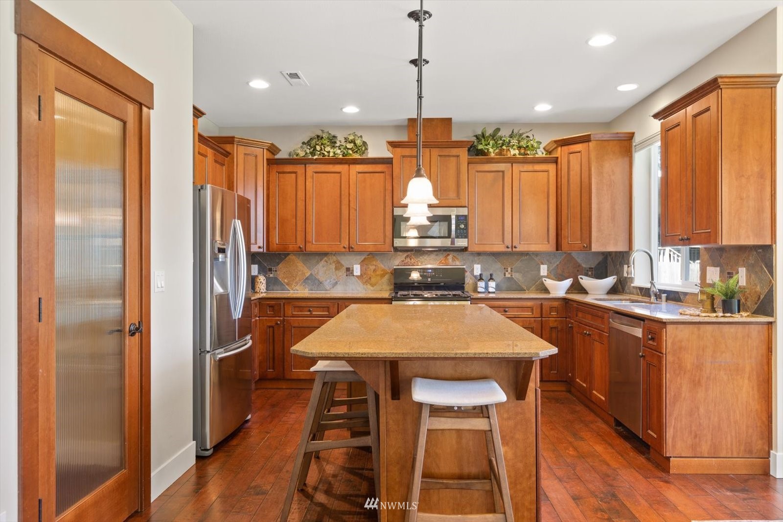 5014 Northeast 24th Street Renton, WA 98059 - Photo 11 of 37 a kitchen with stainless steel appliances granite countertop sink refrigerator and wooden cabinets