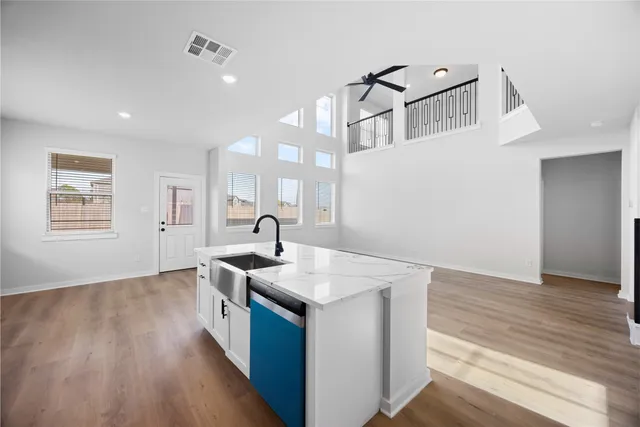 a kitchen with a sink and wooden floor