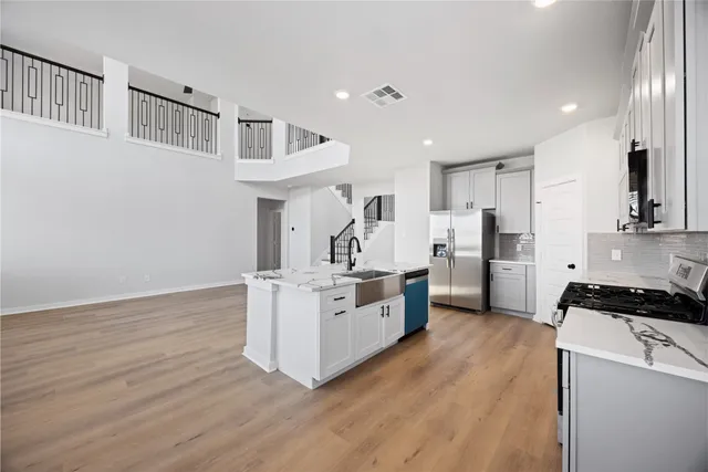 a kitchen with white cabinets and stainless steel appliances