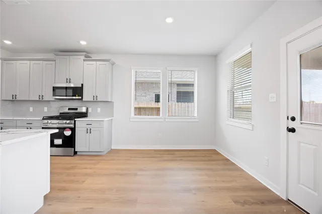 a kitchen with stainless steel appliances granite countertop a stove a sink and a refrigerator