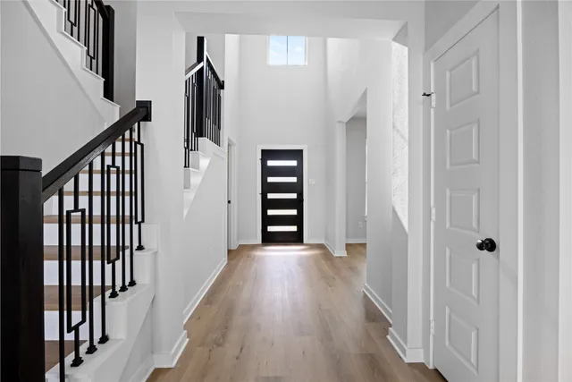 a view of a hallway with wooden floor and staircase