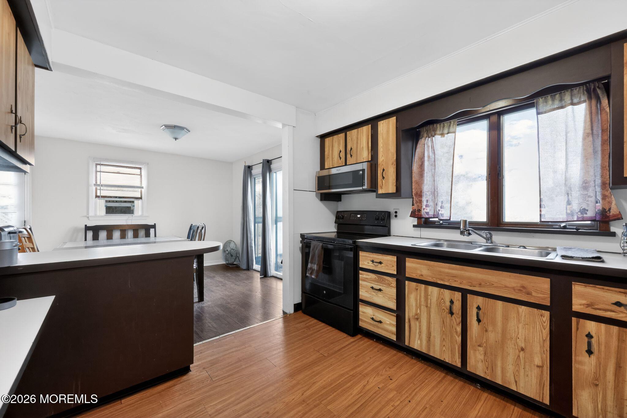 438 Ewingville Road Ewing, NJ 08638 - Photo 24 of 44 a kitchen with stainless steel appliances granite countertop a stove a sink dishwasher a refrigerator and a microwave oven on the wooden floor