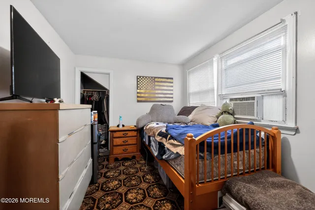 a bedroom with a bed and a baby crib with wooden floor
