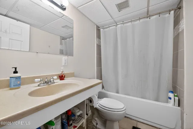 a bathroom with a sink a toilet and shower curtain
