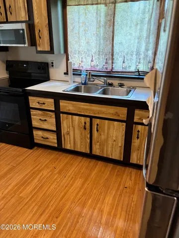 a view of a kitchen with a sink and wooden floor