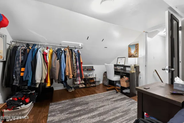 a view of walk in closet with clothes and shoes