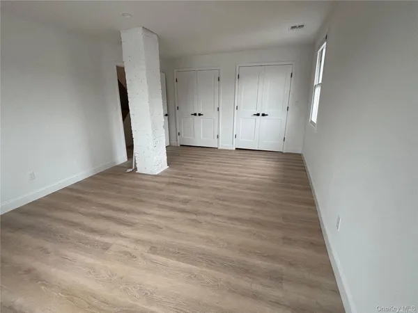 a view of a room with wooden floor